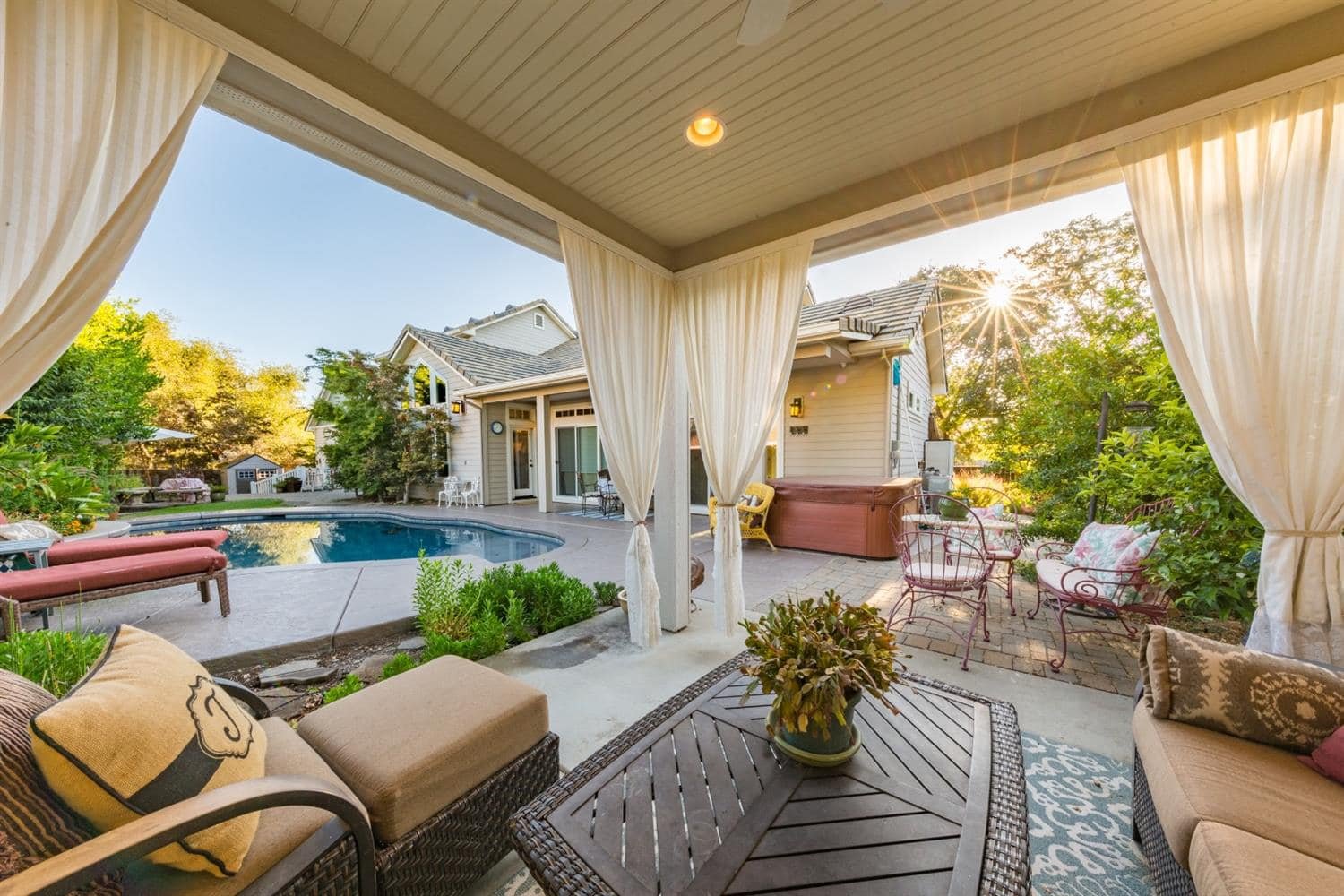 Poolside covered lounge area with curtains