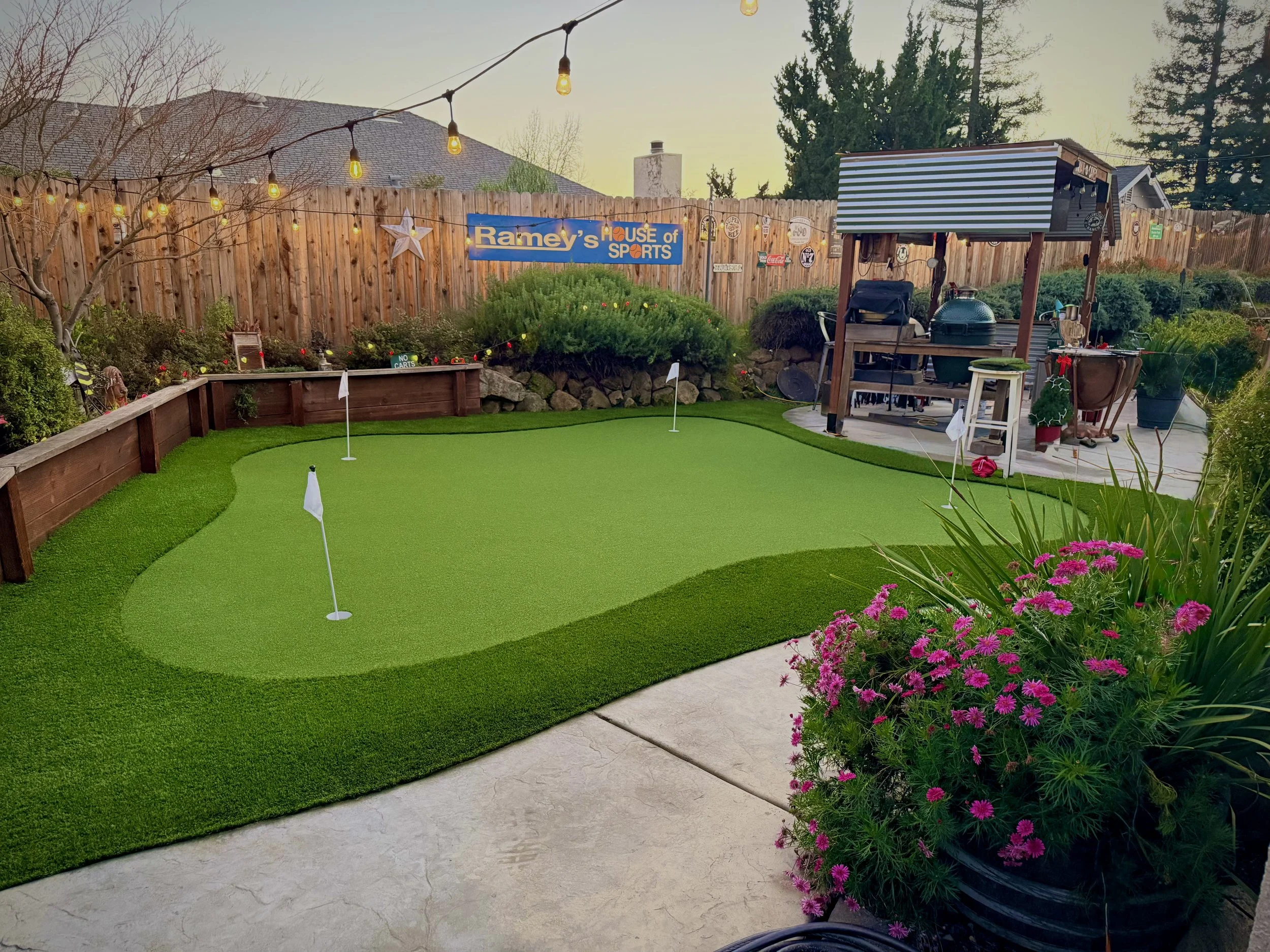 Synthetic turf putting green with raised wood retaining wall