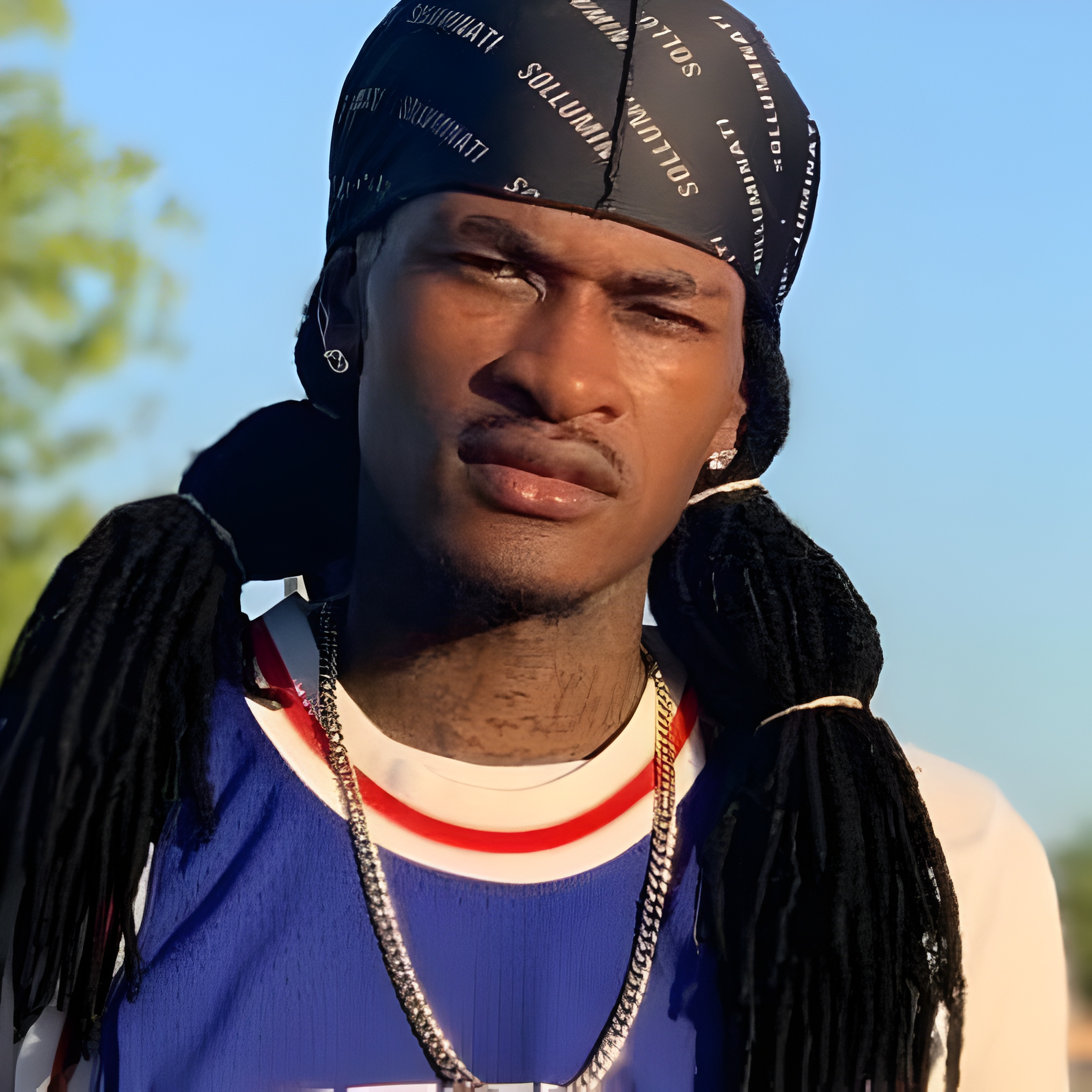 Photo of Solluminati wearing casual streetwear, looking directly at the camera with a serious expression.