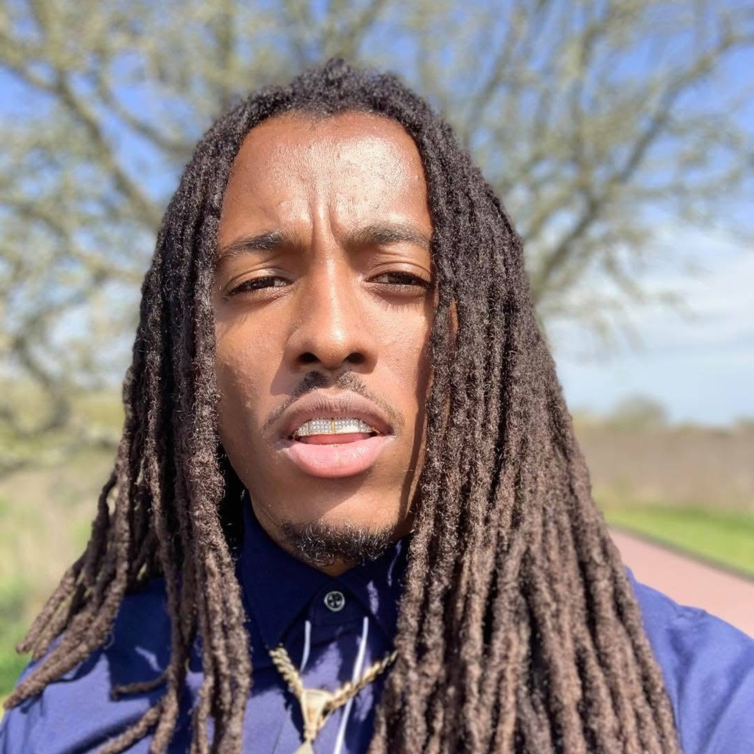 Image of Young Pharaoh, posing confidently, wearing modern streetwear and looking focused.