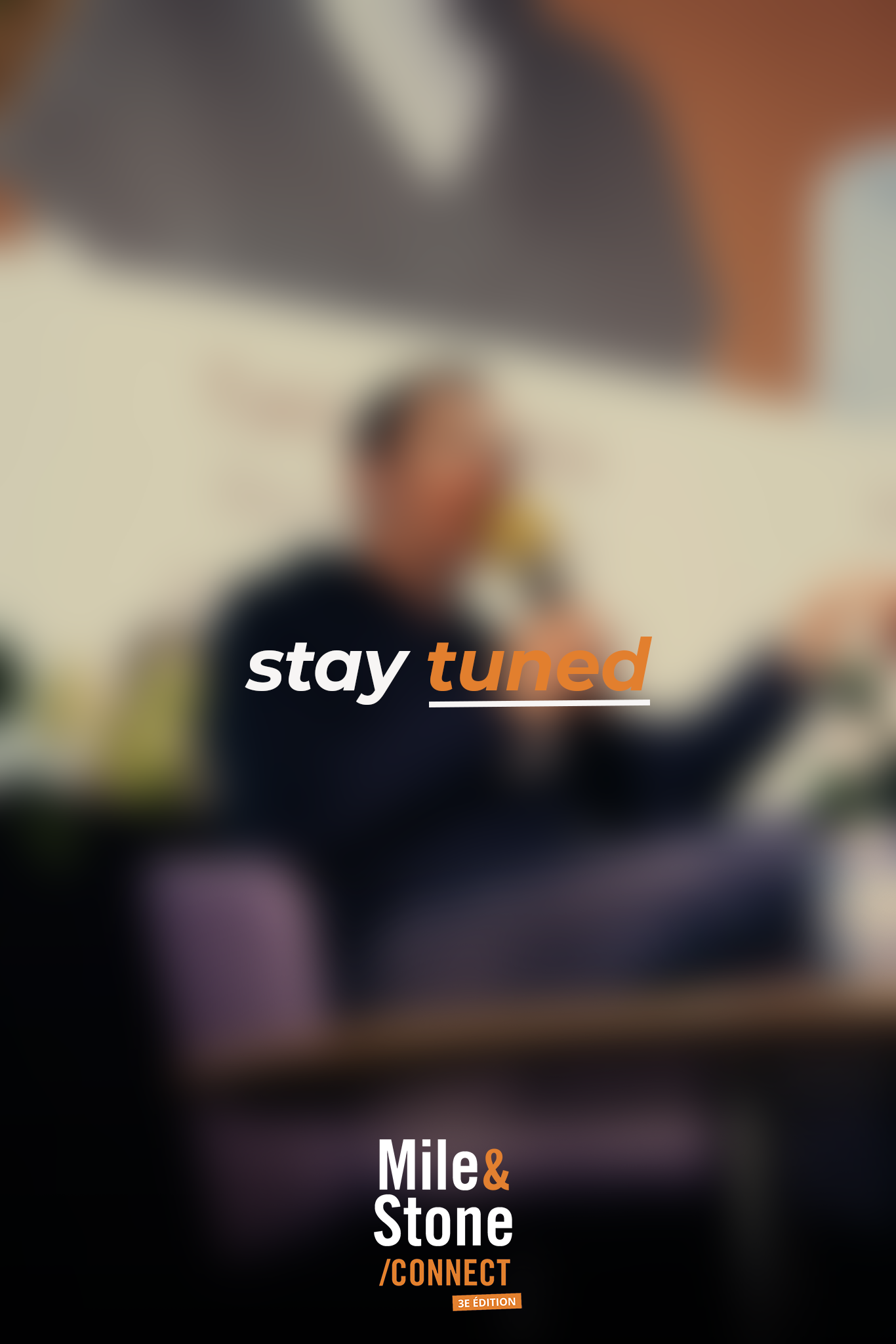 Personne parlant dans un micro, assise dans une pièce avec une décoration moderne. Texte en français : "stay tuned" et informations sur un événement ou un groupe nommé "Mile & Stone".