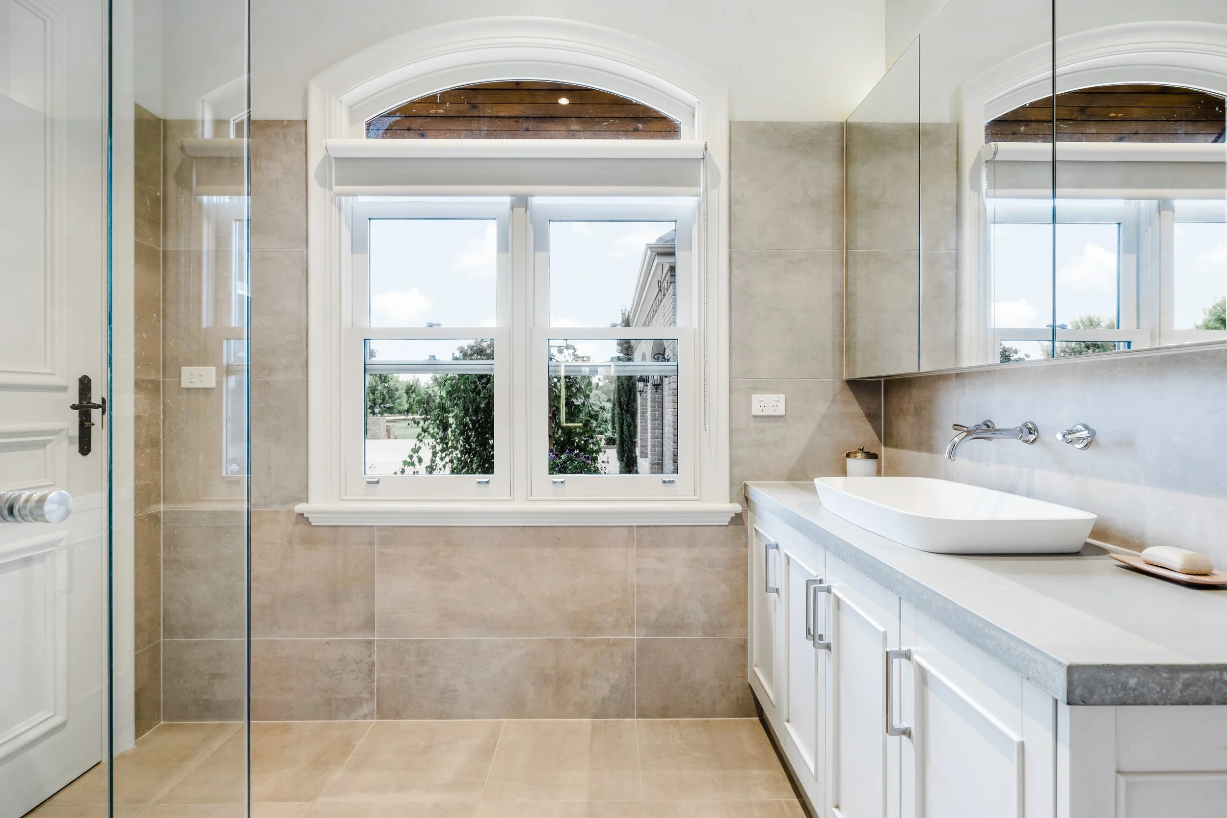 Luxury Bathroom, Porcelain tiles, Neutral Colours, wall mounted tapware, double hung sash windows, above counter basin