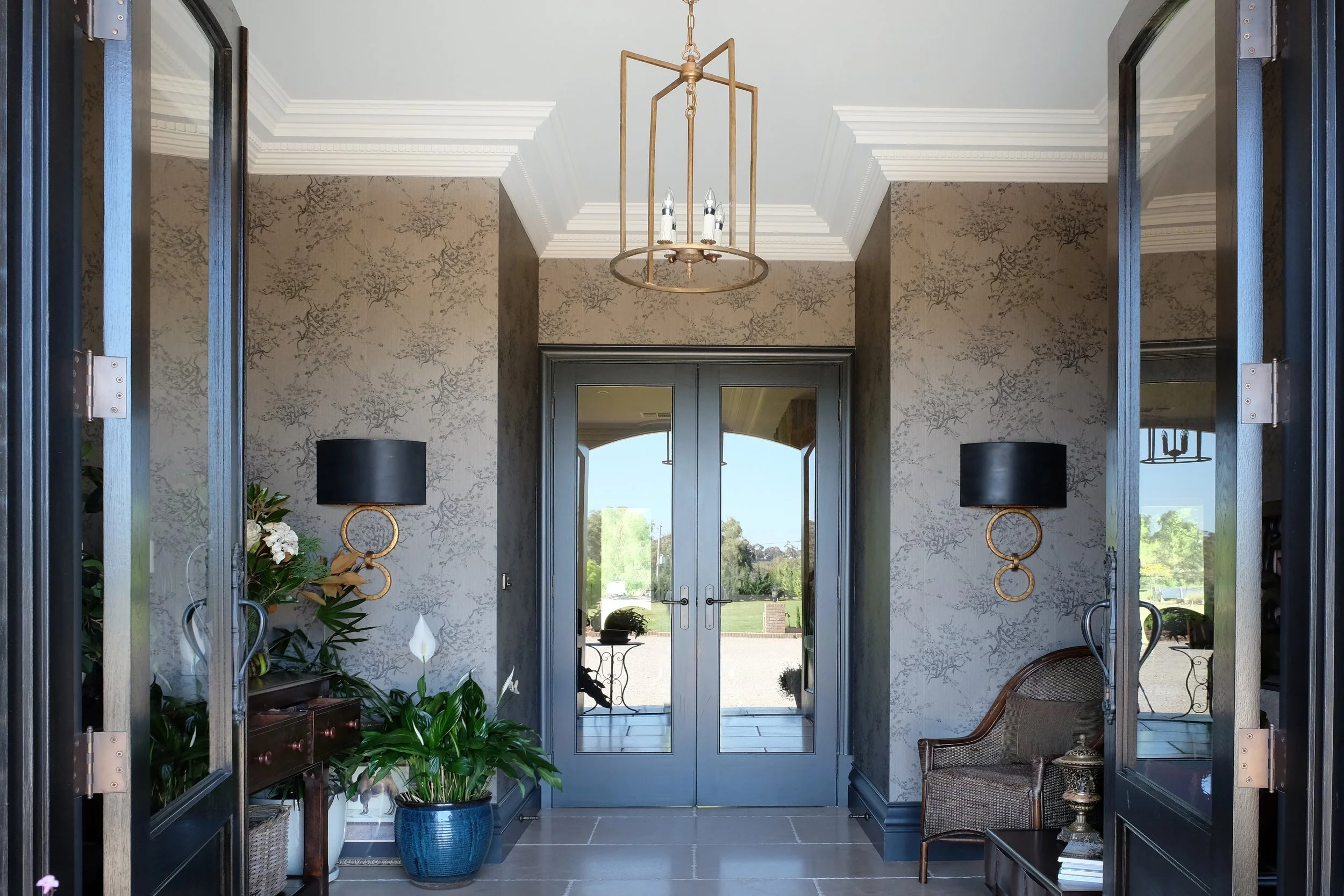 Lime Stone Floors, decorative wallpaper, large double doors with glass, black wall sconces