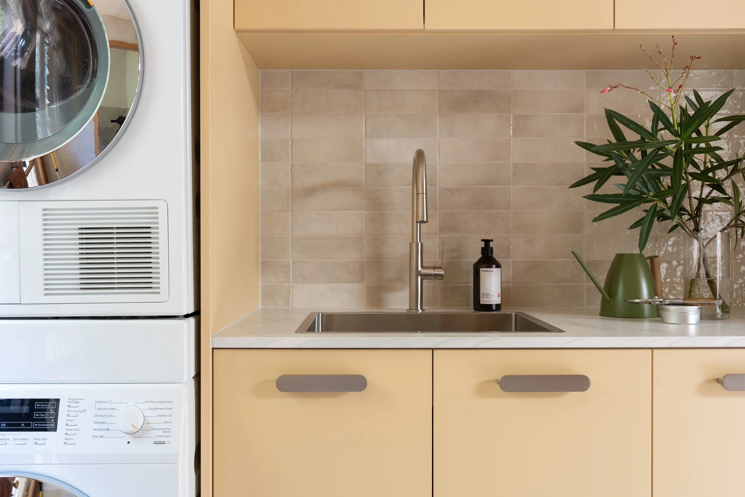 Laundry, laminate cabinetry, porcelaine subway tiles in a pearl finish