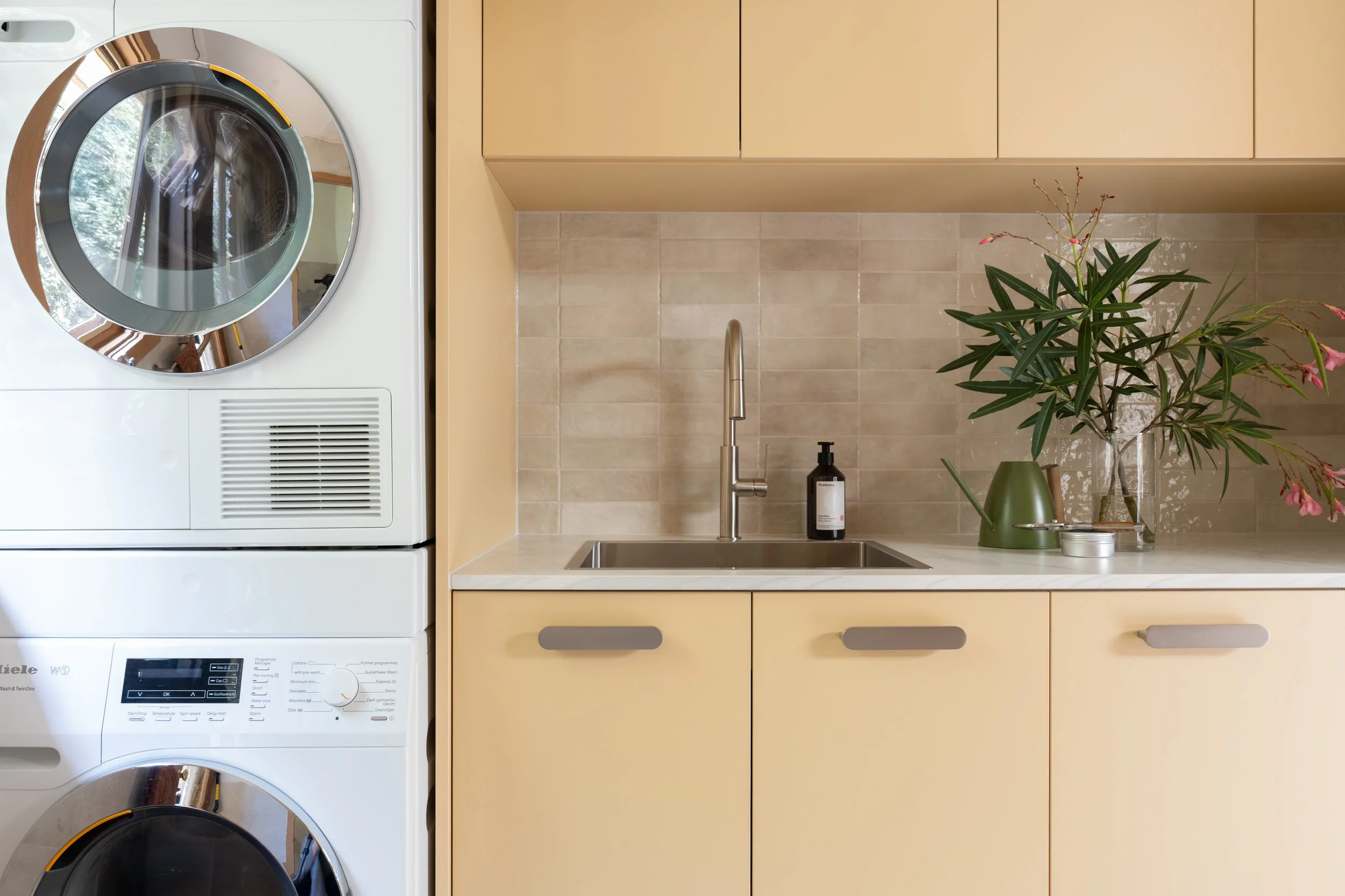 Laundry, laminate cabinetry, porcelaine subway tiles in a pearl finish