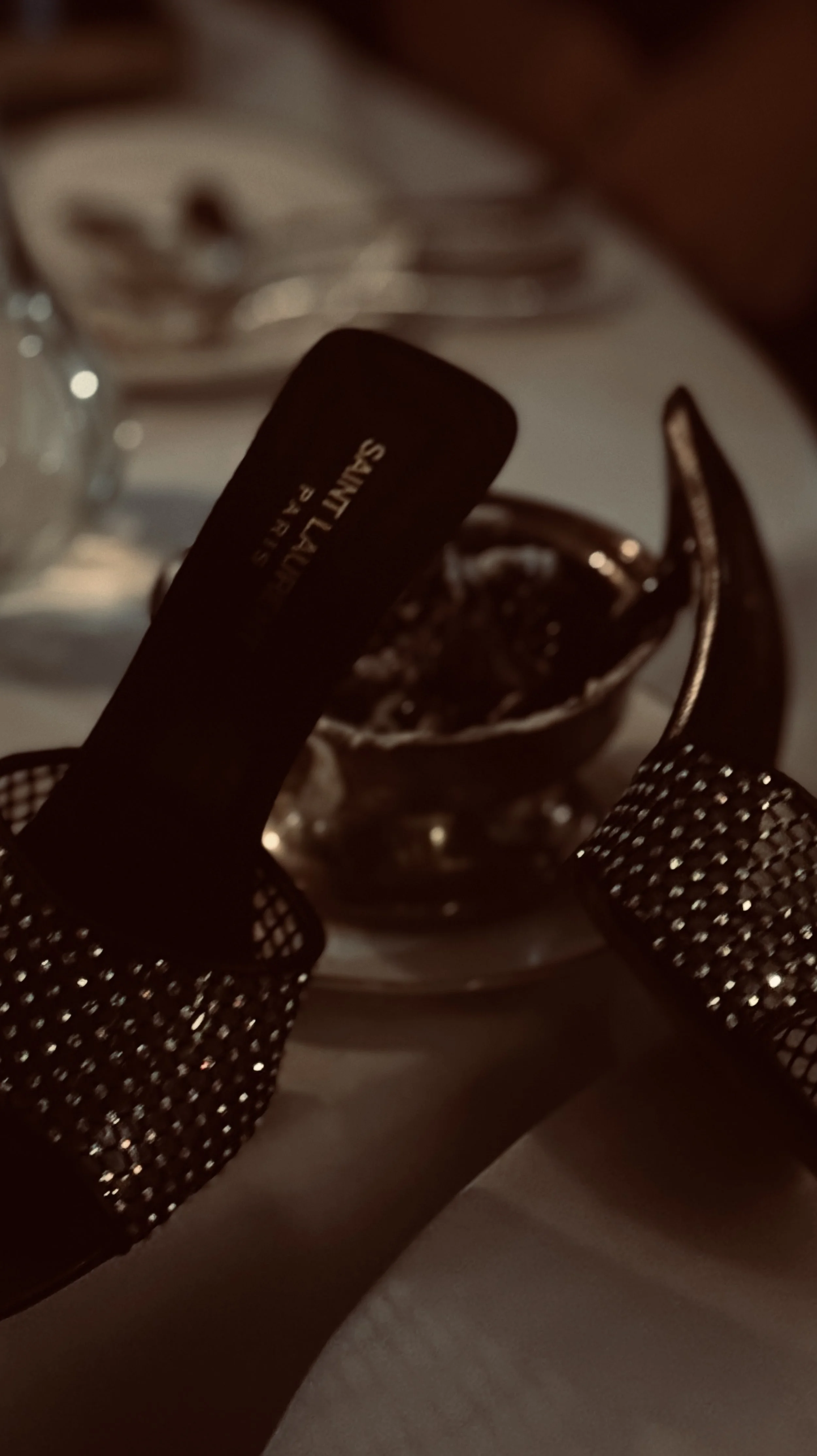 Close-up of a black sink and a silver fork on a table, with a small dish of sauce or jam in the background.