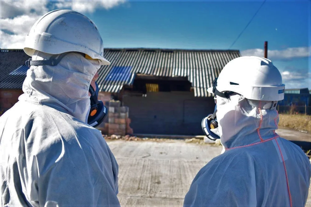 Trained asbestos personnel preparing controlled removal work