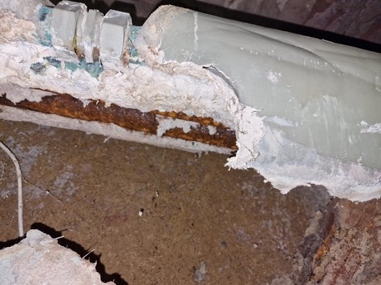 Damaged asbestos thermal insulation around old pipework