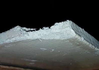Confirmed asbestos insulating board AIB showing broken board edge