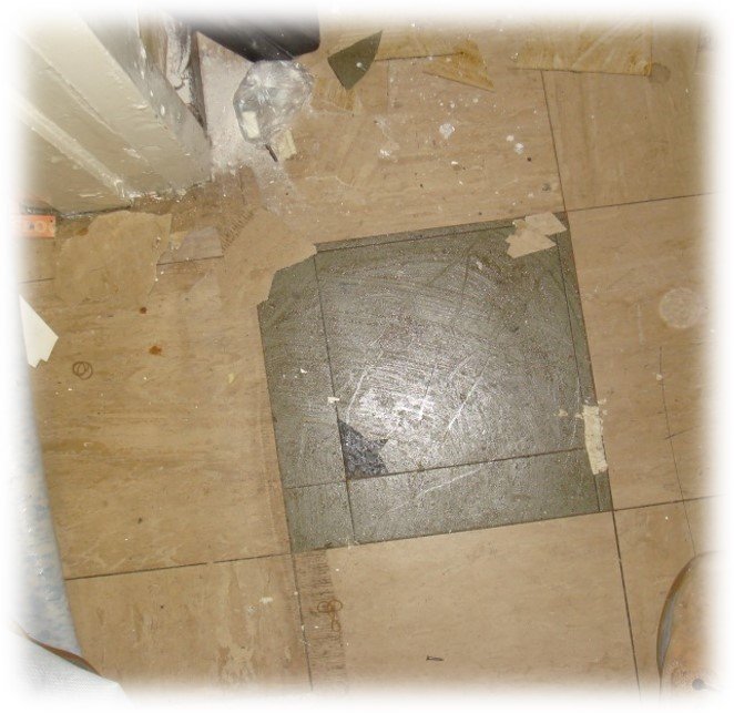 Asbestos-containing bitumen adhesive exposed beneath older floor tiles