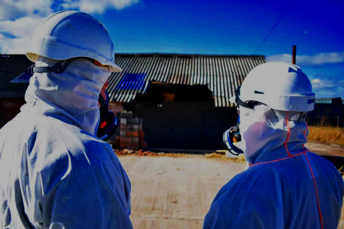 ASM asbestos specialists wearing protective equipment at an industrial site