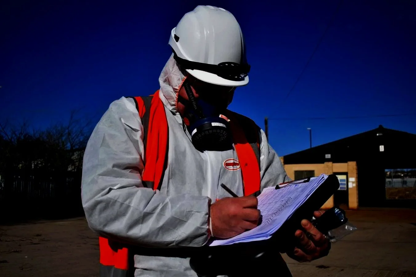 ASM asbestos surveyor carrying out an inspection within an occupied property