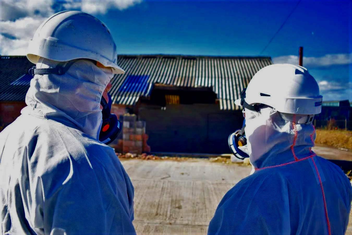 Trained asbestos specialists assessing removal work at a UK property
