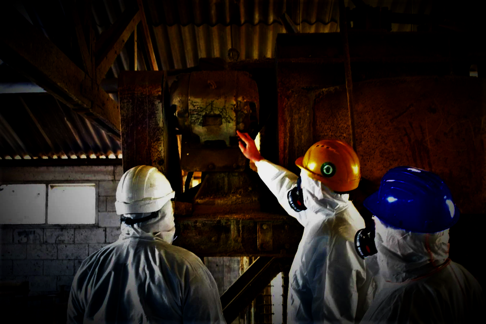 Asbestos specialists reviewing an industrial structure during a site inspection