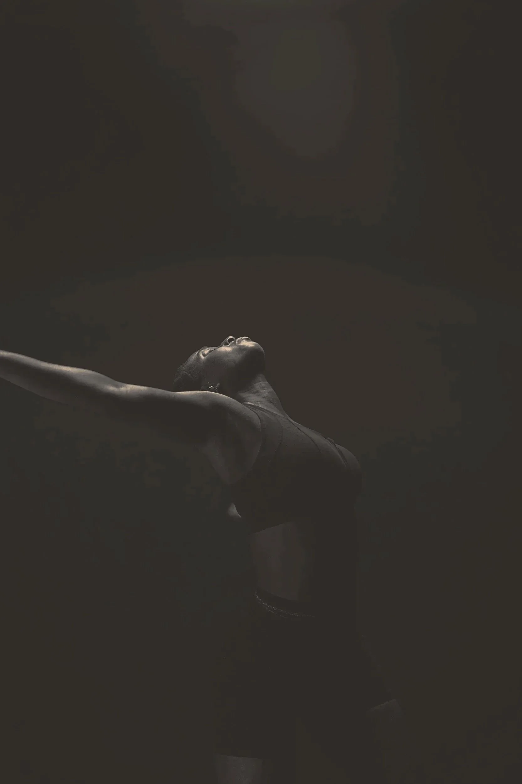 Woman looking upward with open posture, representing energy, release and balance