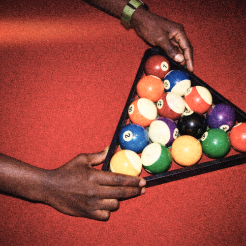 Two hands holding a black triangular rack with colourful pool balls on one of the beautiful pool tables at The Lucky Goat.