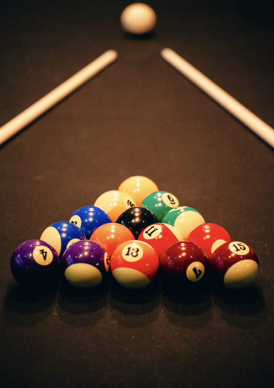 Two hands holding a black triangular rack with colourful pool balls on one of the beautiful pool tables at The Lucky Goat.