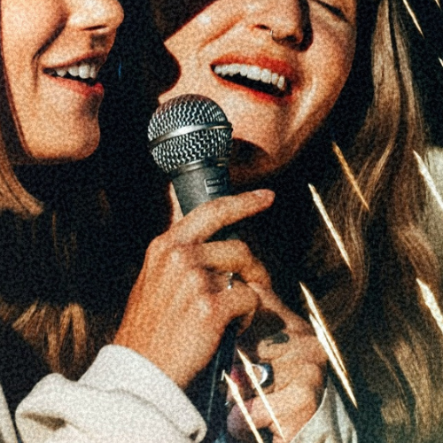 Two women absolutely belting out their favourite karaoke banger in one of the stunning Karaoke rooms at The Lucky Goat. 