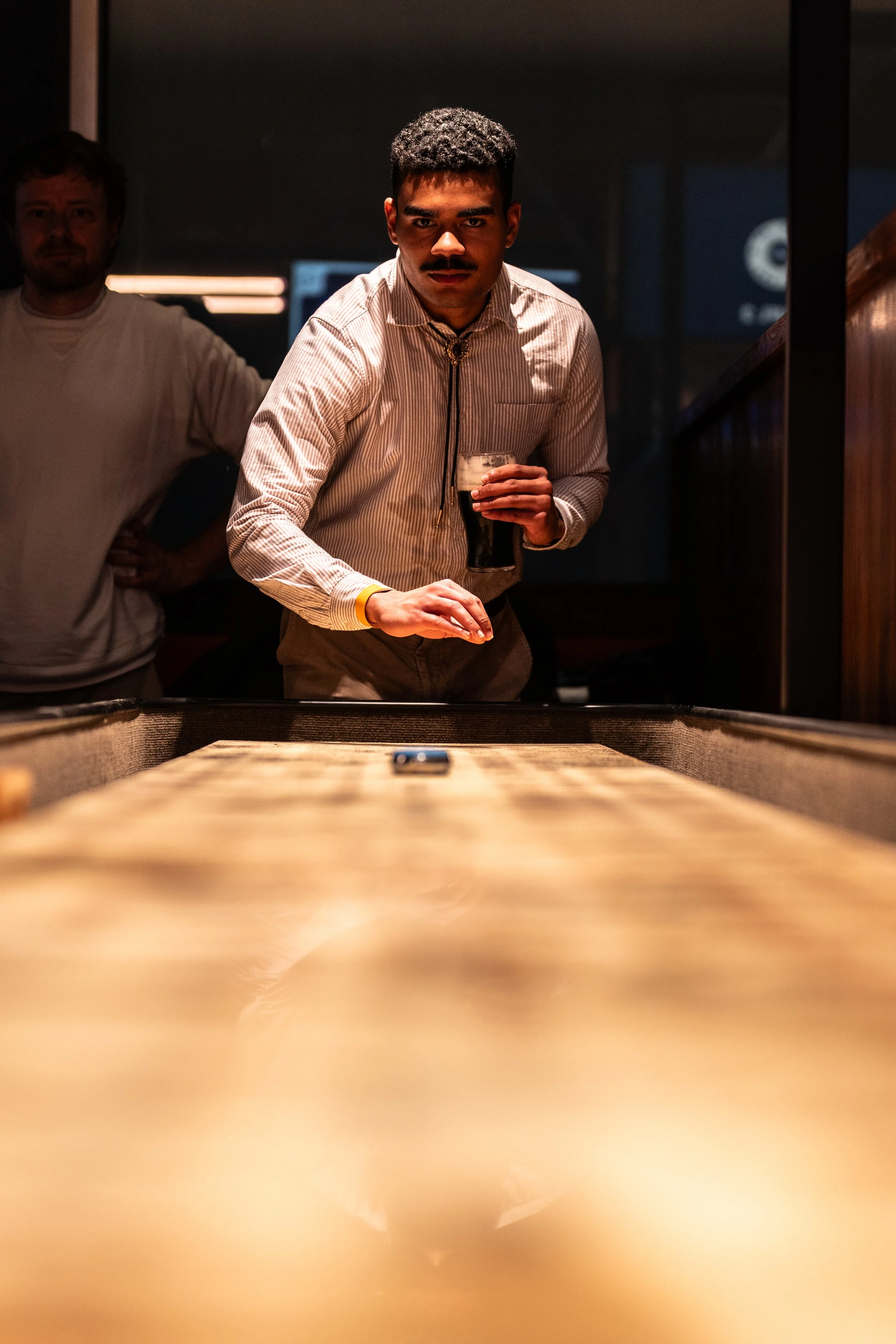 Close-up of a shuffleboard puck on a wooden shuffleboard table in The Lucky Goat game zone.