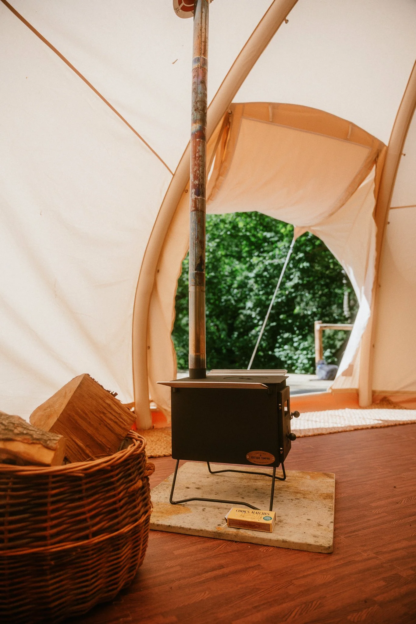 wood burner set up with logs inside a dome tent
