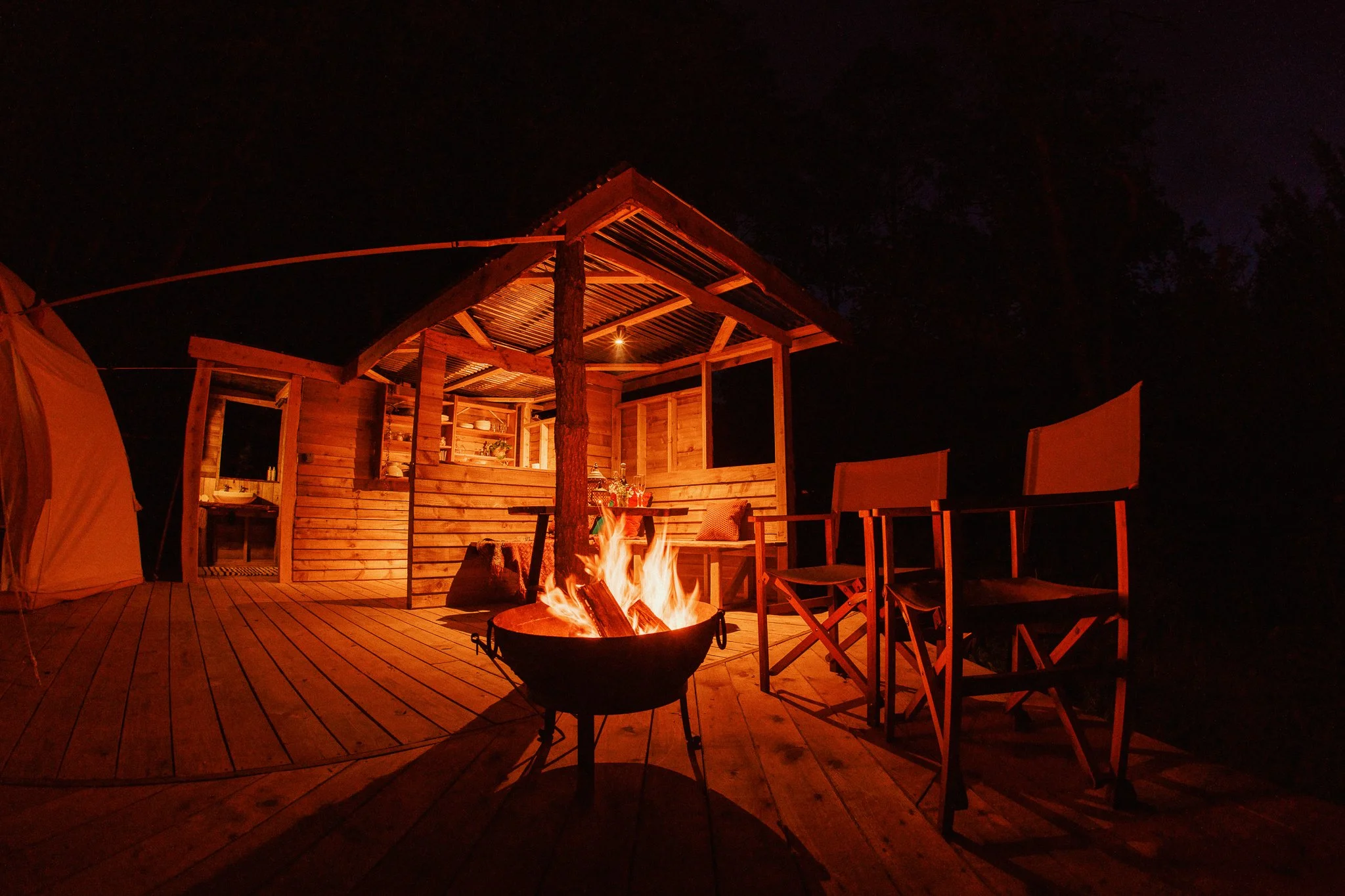 Fire pit lighting up glamping kitchen with chairs 