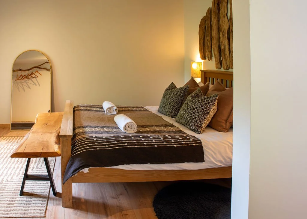 Bedroom of Brook off-grid cabin, kingsize bed with wood work details 