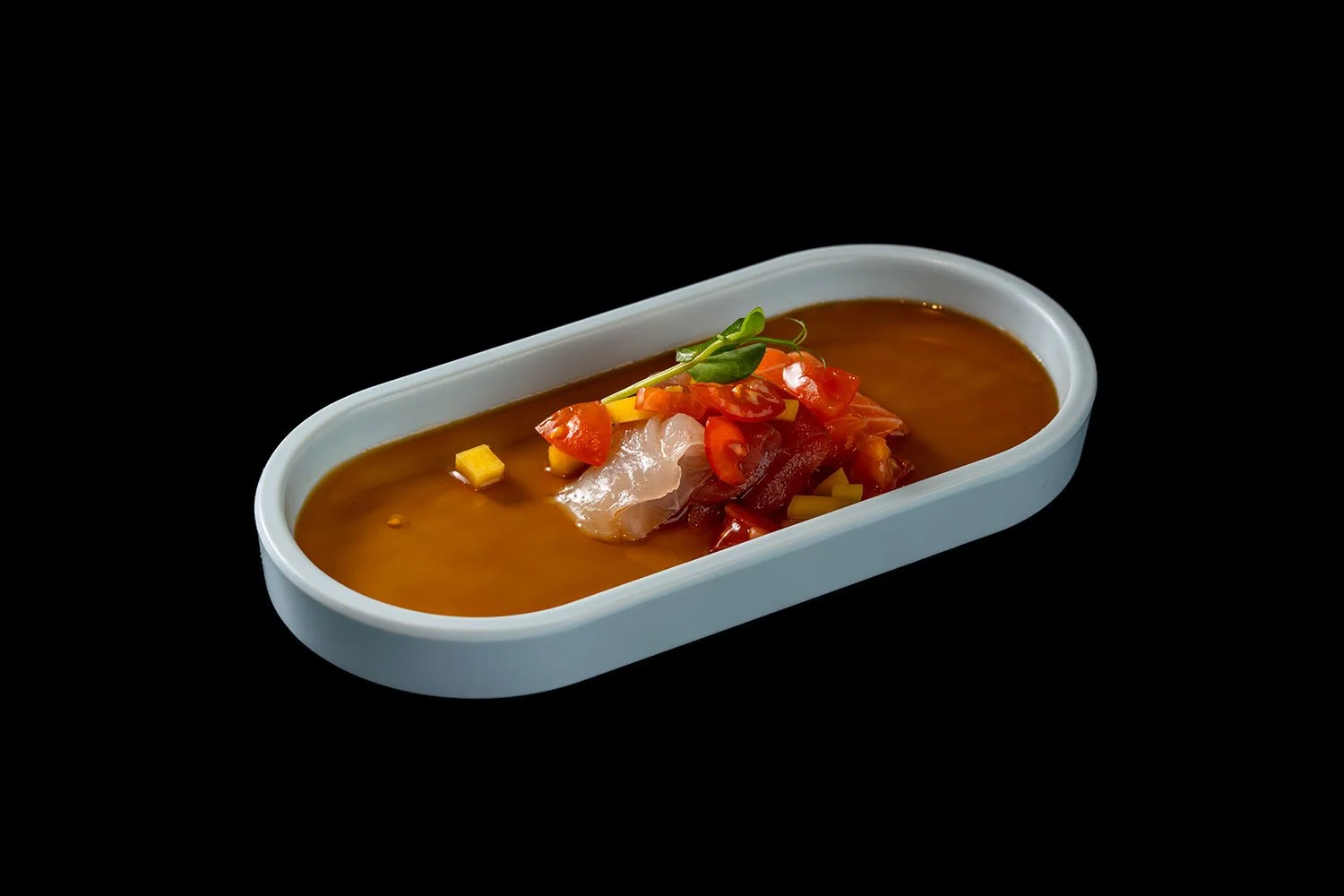 Hühnchensuppe mit Gemüse und Frühlingszwiebeln in einer weißen Schale auf schwarzem Hintergrund.