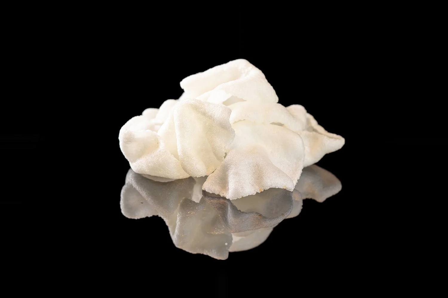 Weiße Popcorn auf spiegelndem schwarzen Hintergrund