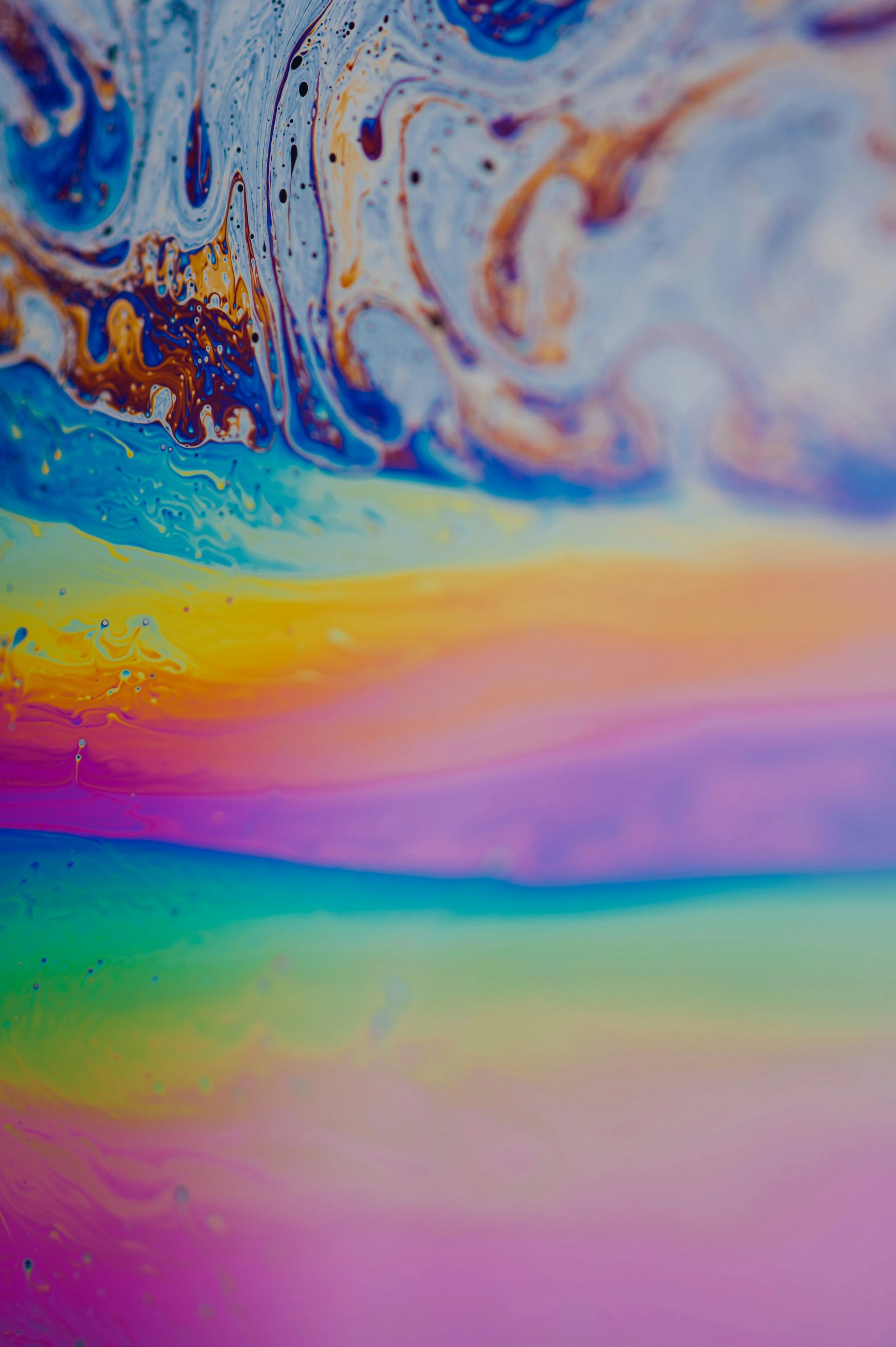 Abstract swirl of colorful liquids in blue, orange, pink, purple, and yellow hues creating a marbled pattern.