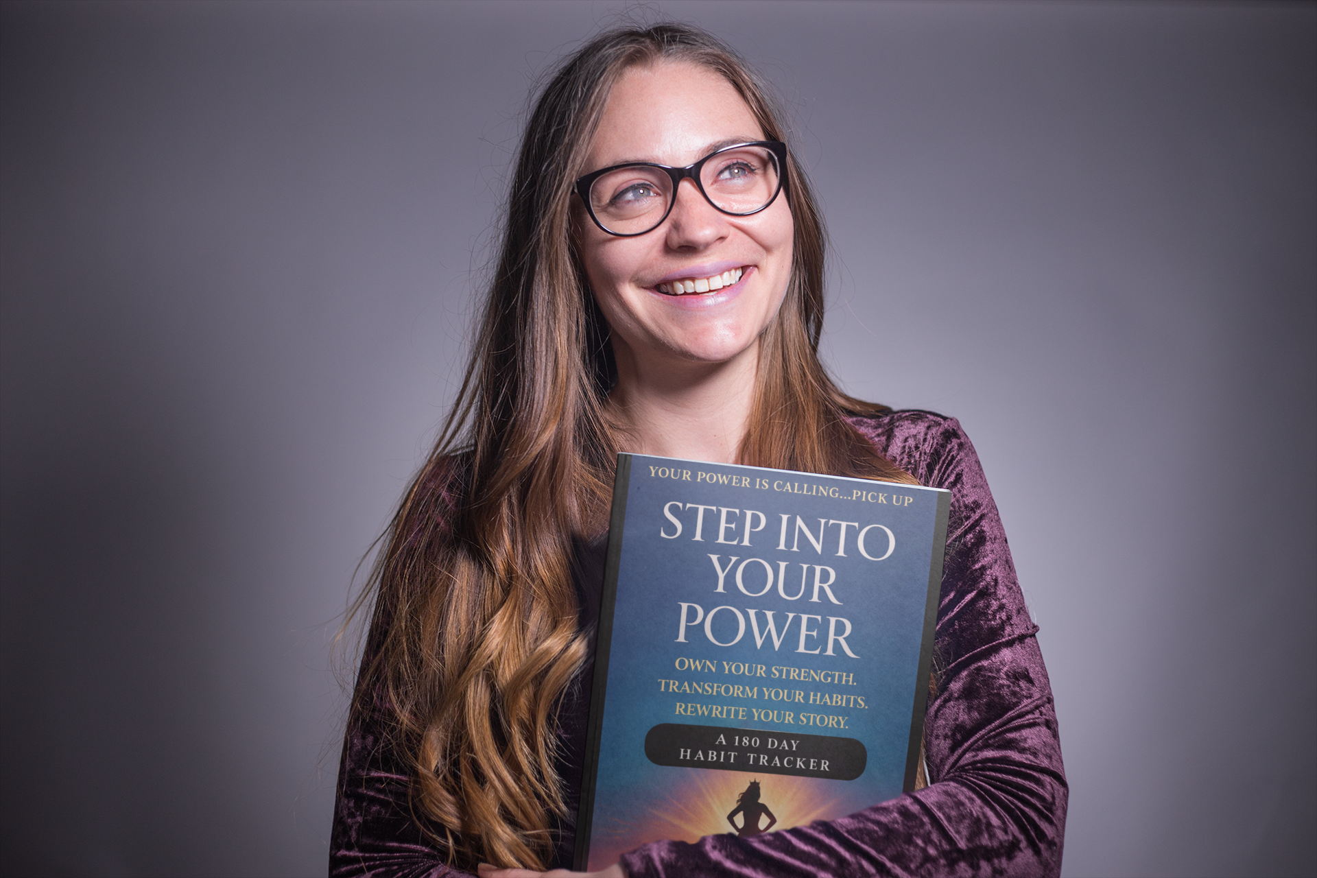 happy-woman-holding-a-book-mockup-in-a-grey-room-a19258.png