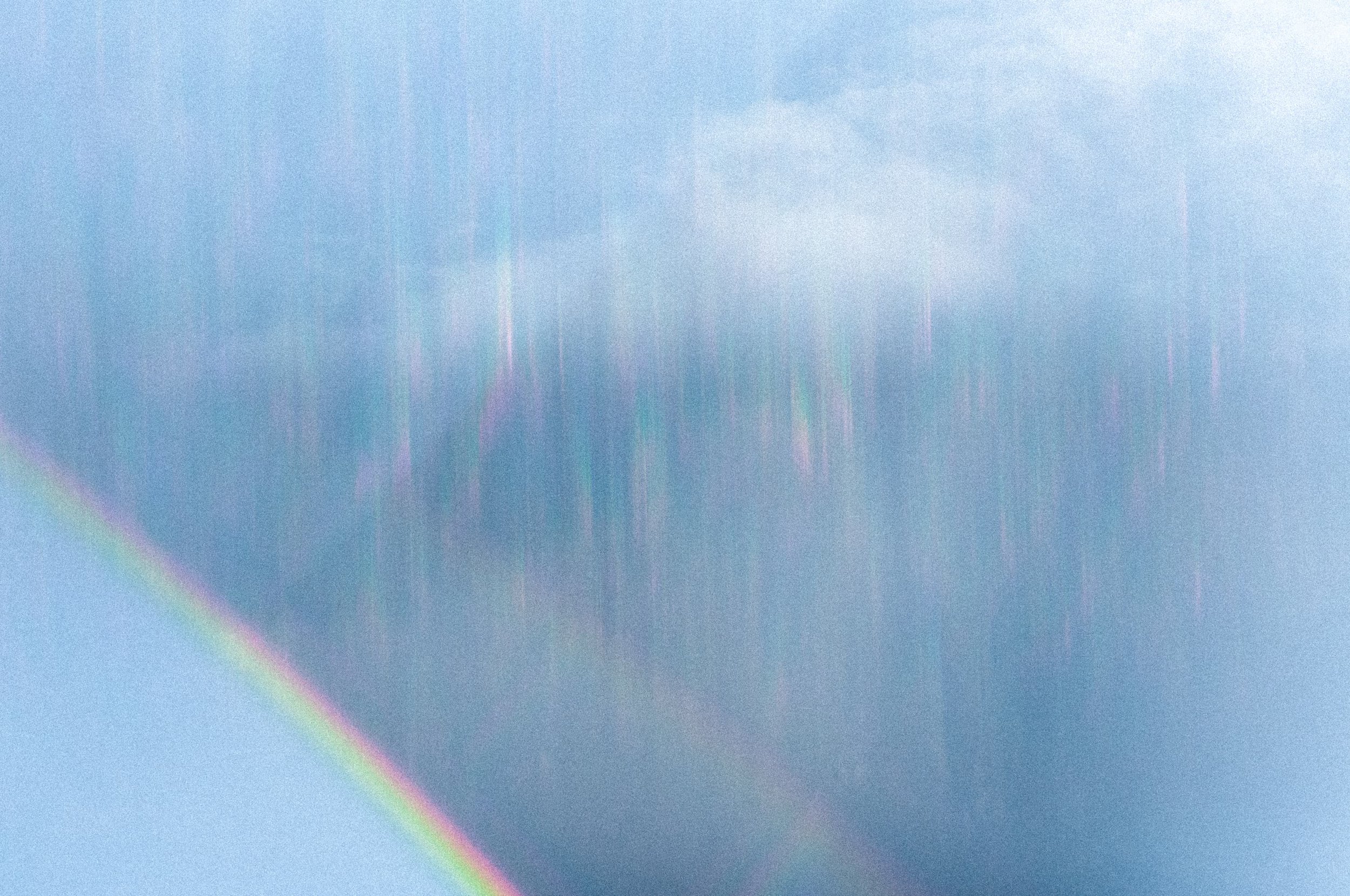 空と虹色の光線が映った画像