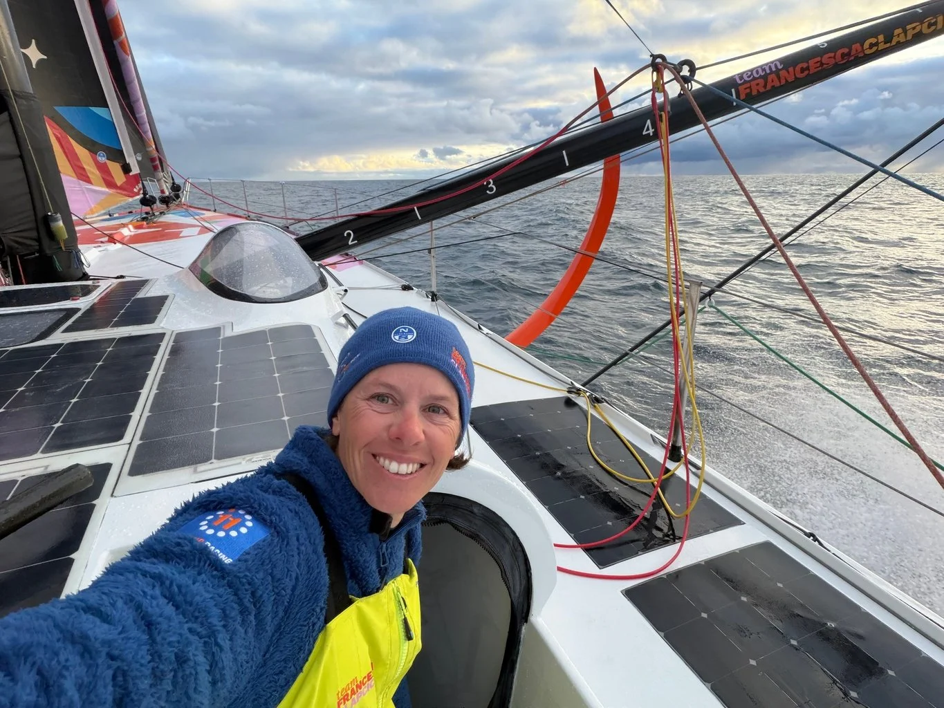 Francesca Clapcich smiles at the camera outside onboard her sailboat 11th Hour Racing