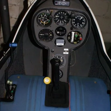 Cockpit eines Flugzeugs mit verschiedenen Instrumenten und Steuerknüppel.