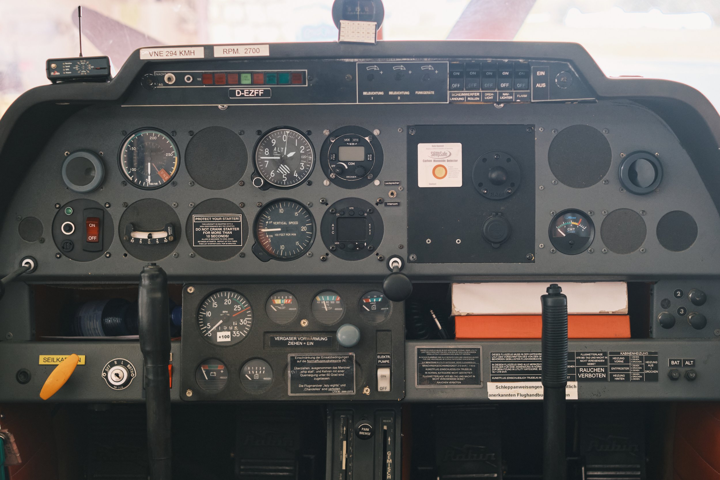Cockpit eines Flugzeugs mit verschiedenen Instrumenten, Anzeigen und Steuerknüppeln.