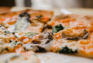 Mehrere Pizzastücke mit verschiedenen Belägen auf einem Pizzakarton