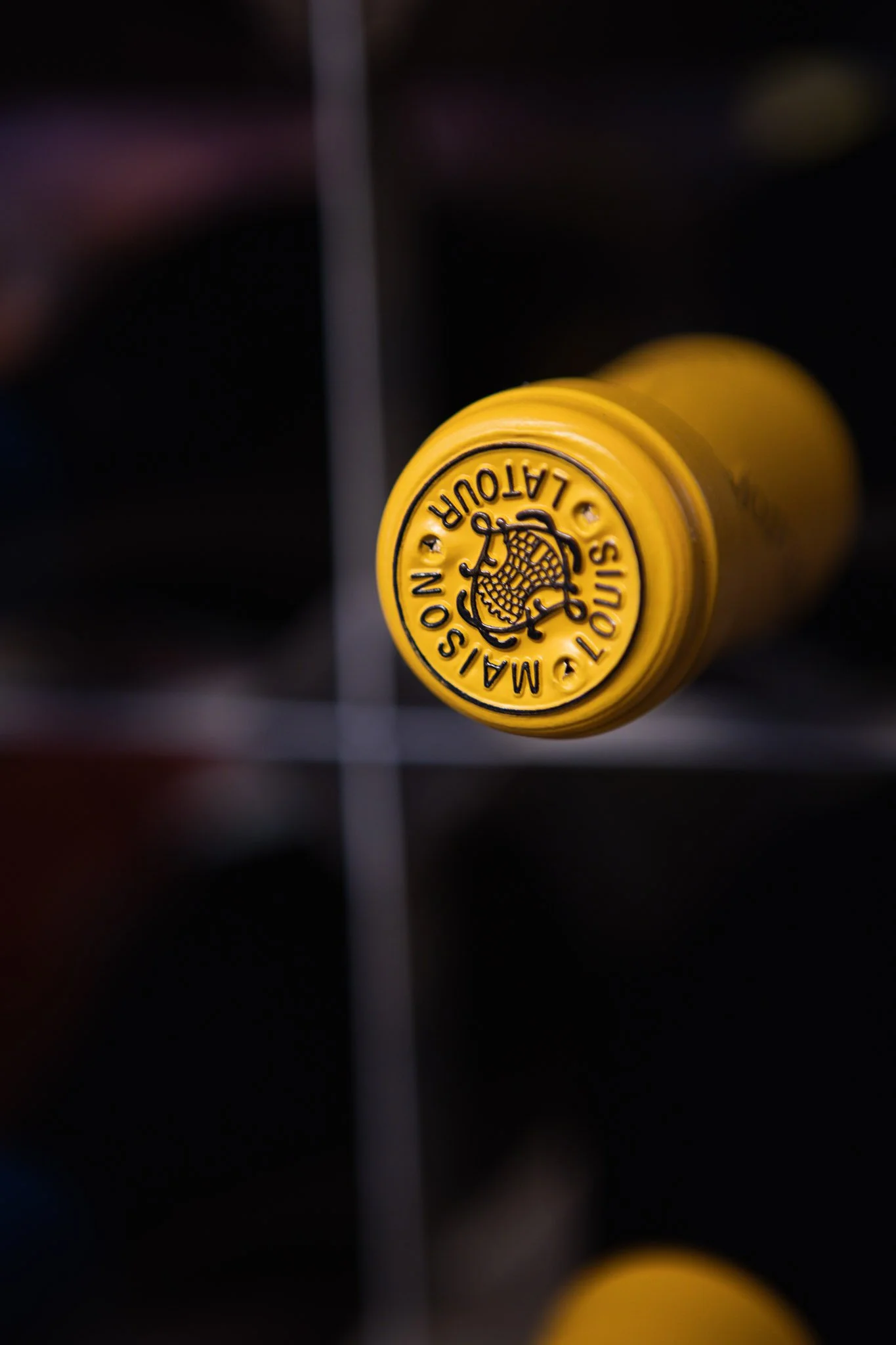 Close-up of a yellow tennis ball with the brand name 'MASTOUR MASTOUR' printed on it, against a dark background.