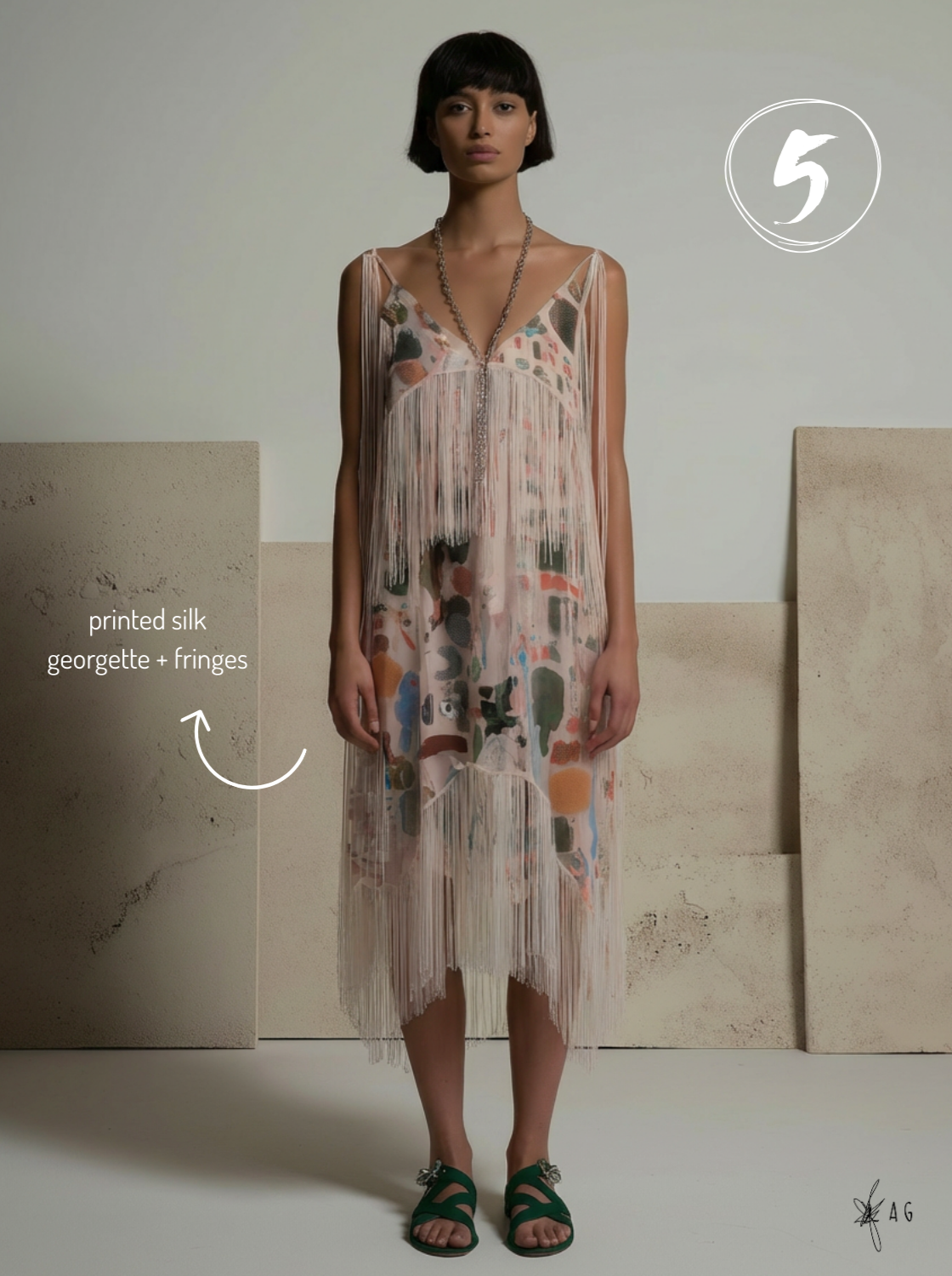 Model wearing a printed silk dress with georgette and fringes, standing against neutral background, accessorized with a long necklace and green footwear.