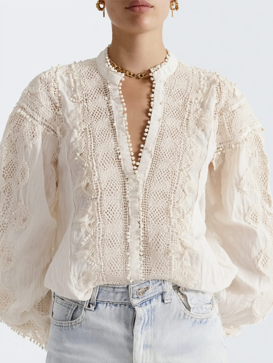 A woman wearing a white, lace, embroidered blouse with puffed sleeves, paired with light-wash jeans, accessorized with gold earrings, a chain necklace, and a choker.