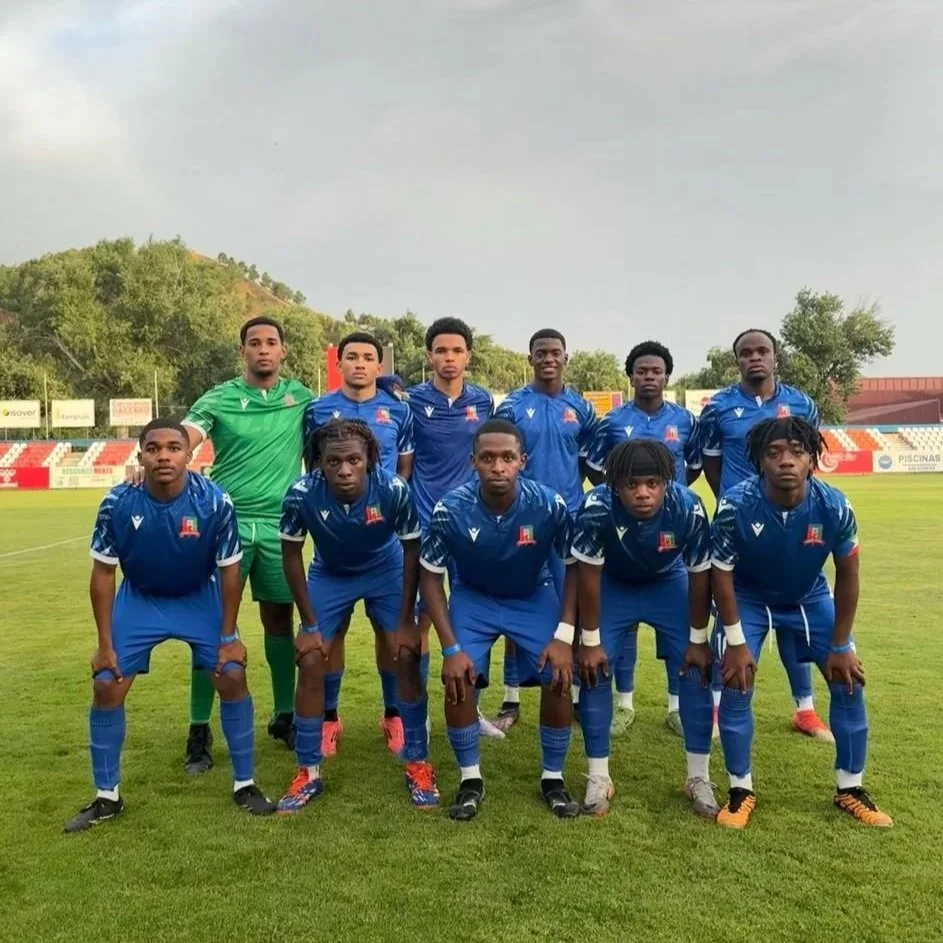 Grupo de futbolistas en uniforme azul en un campo de fútbol.