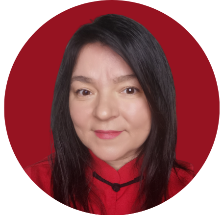 A woman with long dark hair wearing a red top with black detailing, smiling at the camera against a red background.