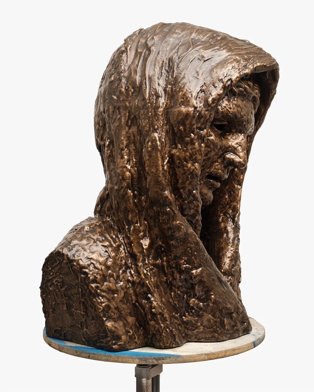 Bronze bust sculpture of a woman with a head covering, in a three-quarter profile view.