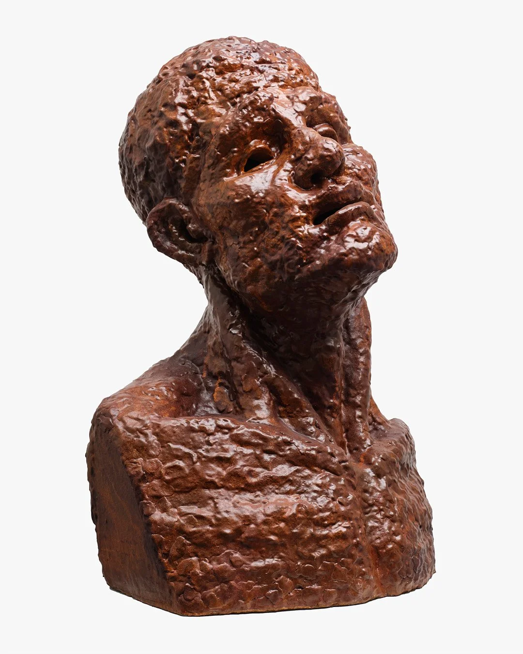 A sculpture of a human bust with a textured surface, depicting a person with short hair and a contemplative expression, made of a reddish-brown material.
