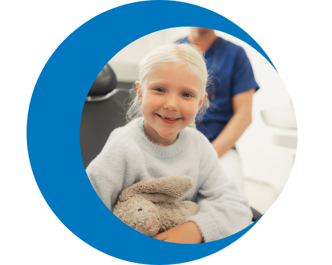 Child in clinical setting holding comfort item while engaging in coping during medical visit