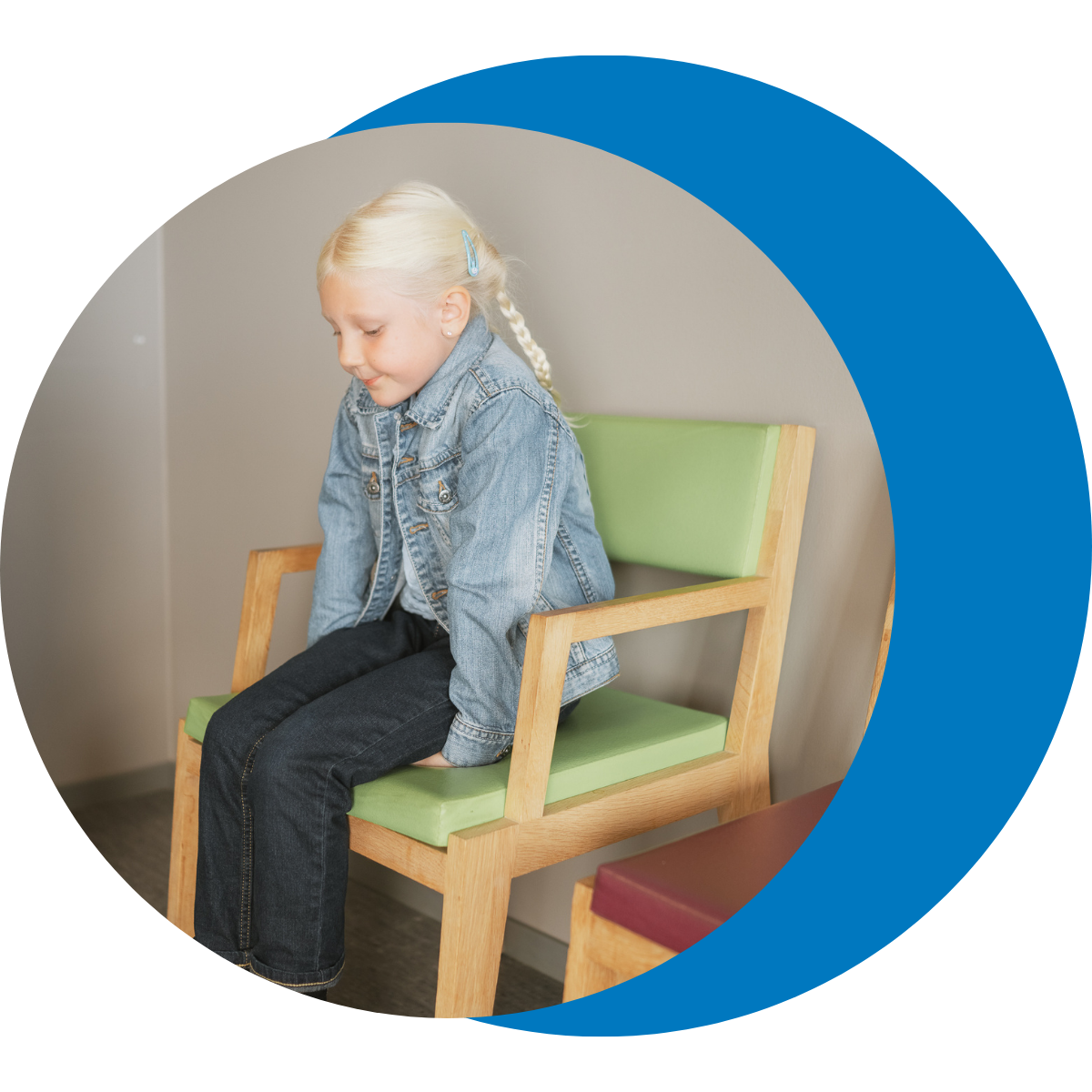 Child seated in clinic waiting area practicing quiet coping before healthcare visit