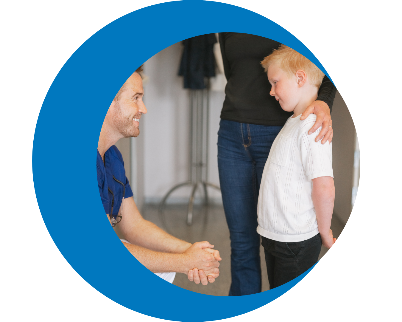 Child in clinical setting holding comfort item while engaging in coping during medical visit