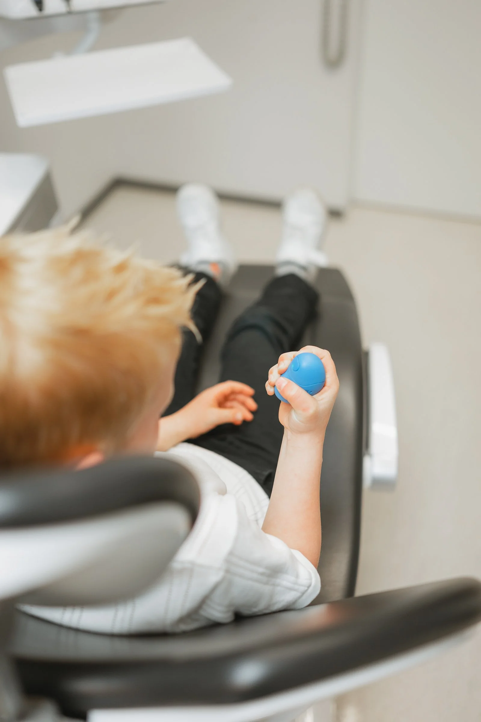 Child holding Grasp device during treatment appointment
