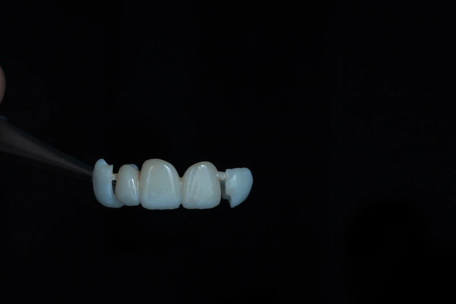 A dental prosthetic or crown set shown against a black background.