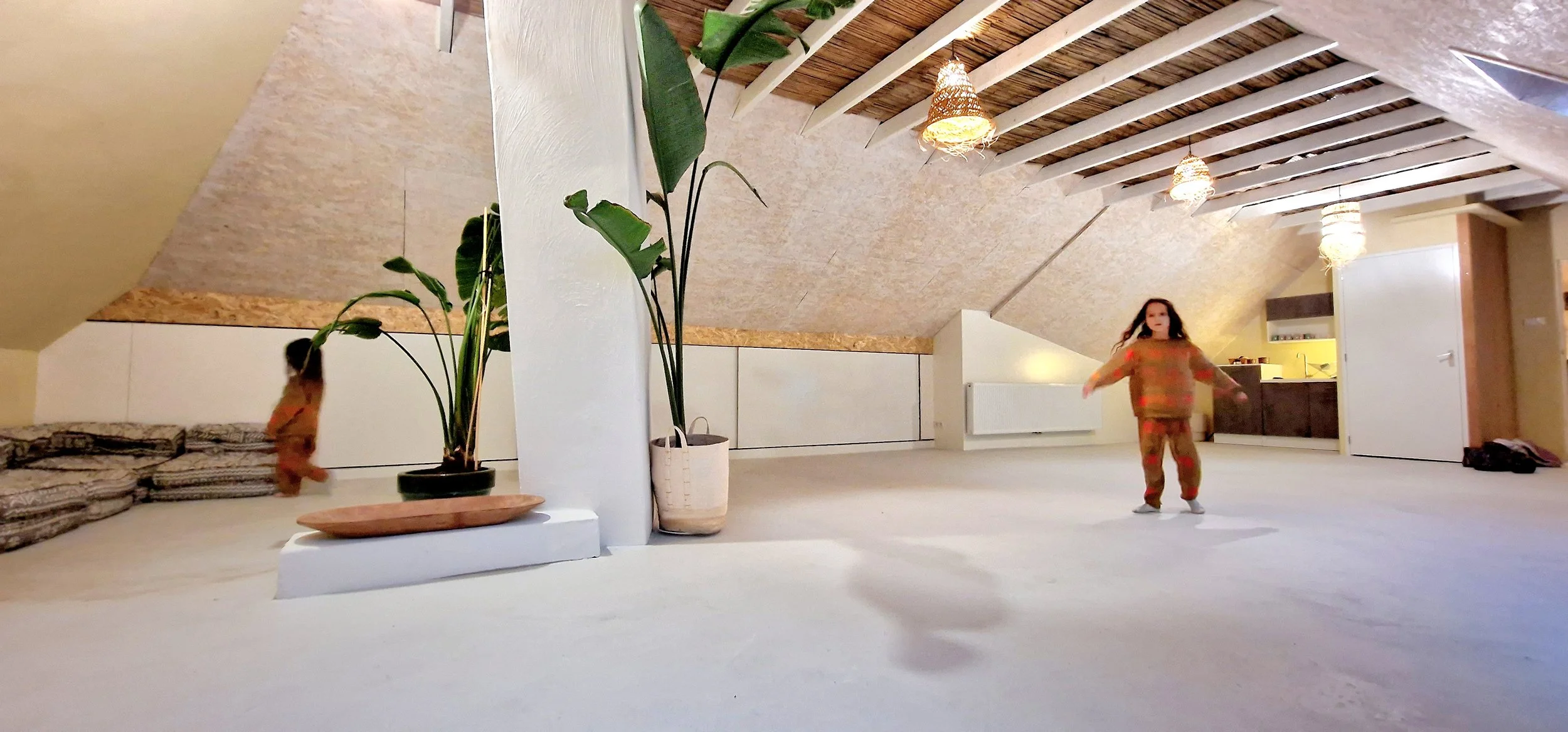 Houten dakspanten en zacht licht in getransformeerde zolderruimte