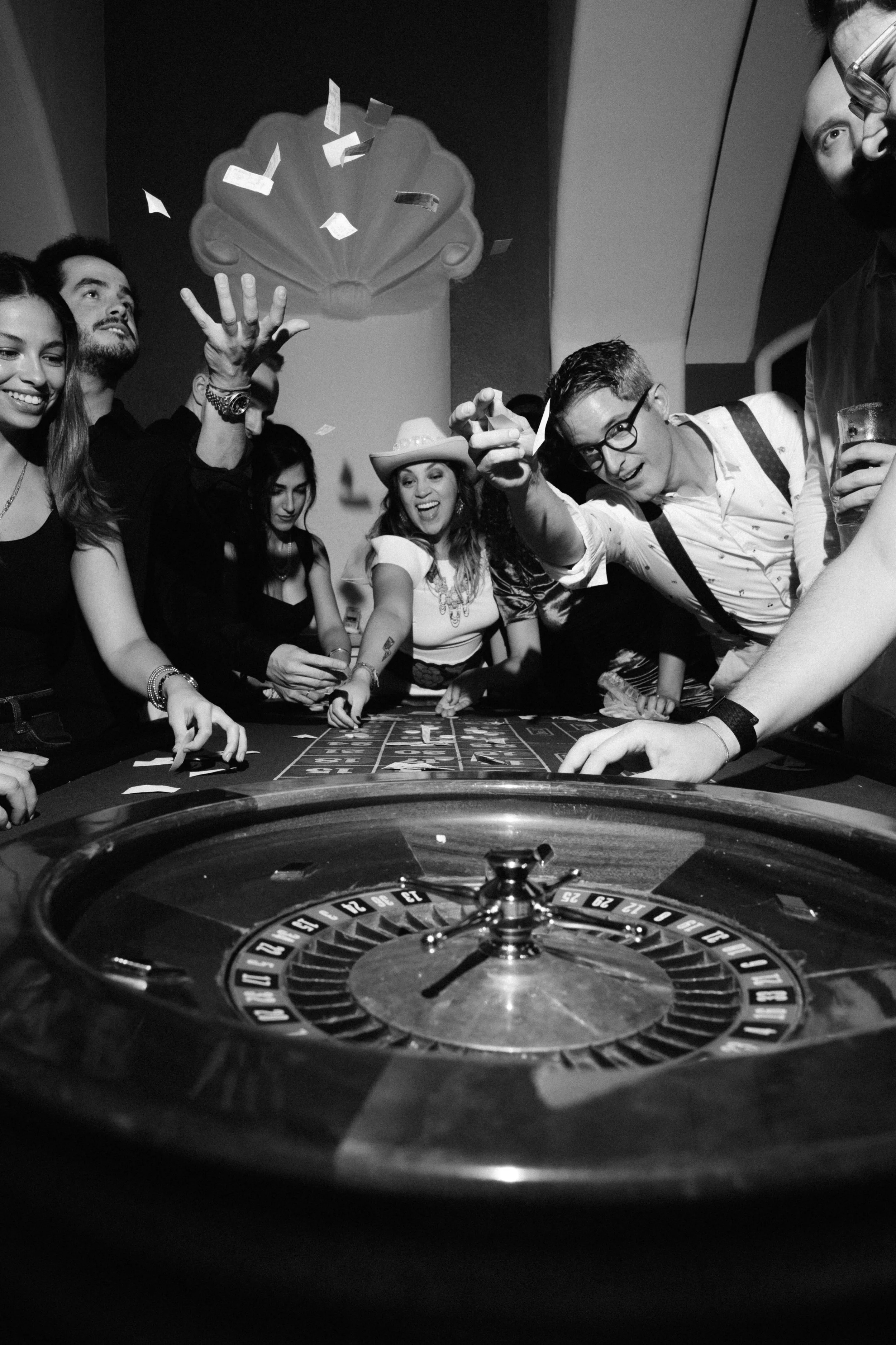 People playing roulette at a casino, with confetti falling and celebrating.