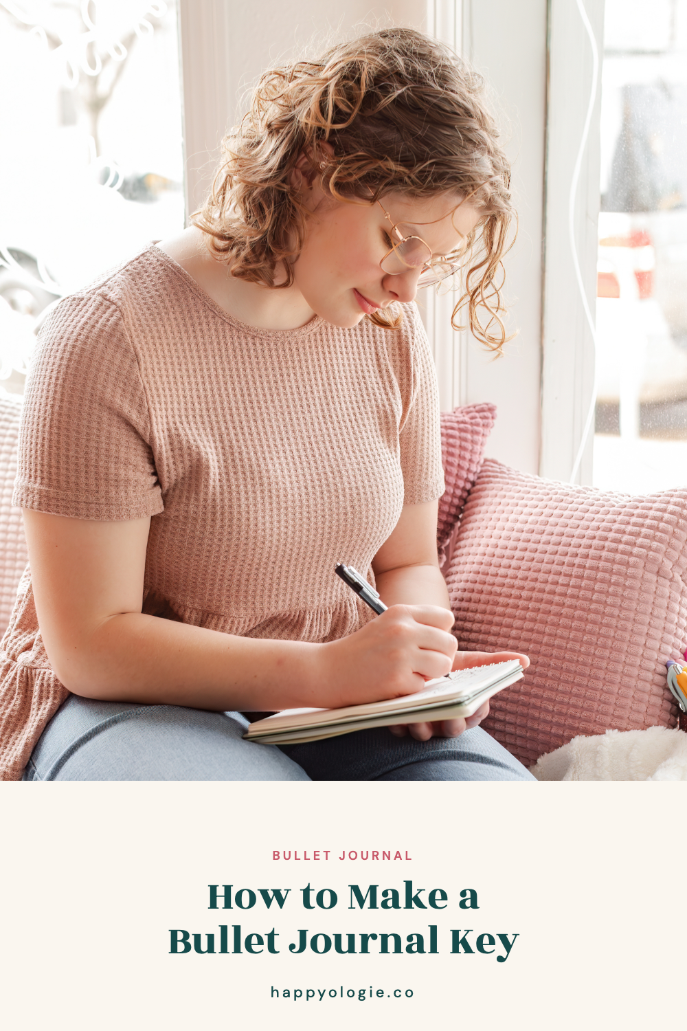 Student writing in a small notebook while sitting beside a sunny window.